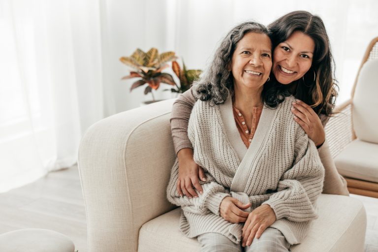 Mother and Daughter Daughter hugging her mother while posing for a picture. They both look happy.