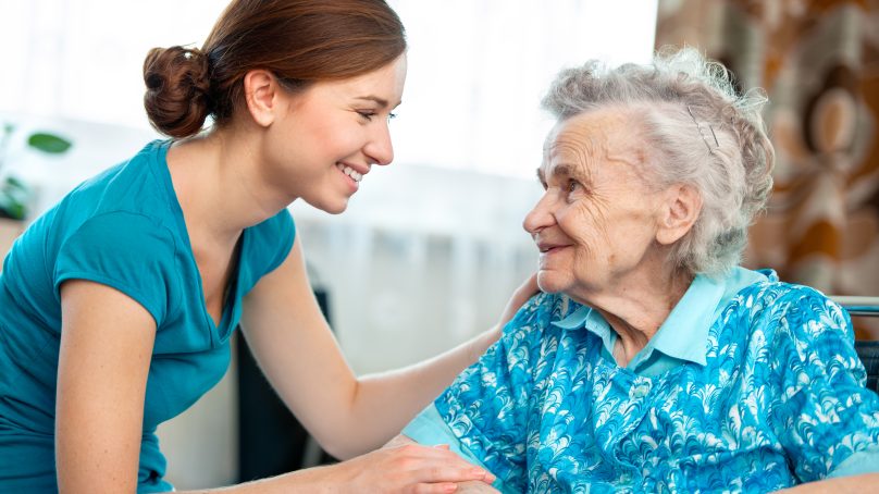 Young woman greeting an elderly woman