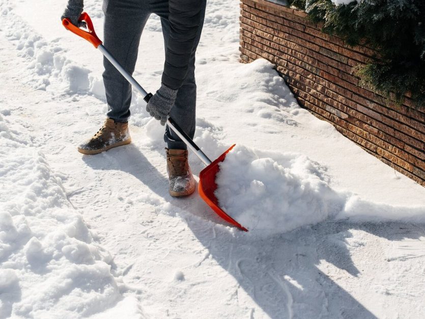 A person clearing snow with a shovel.