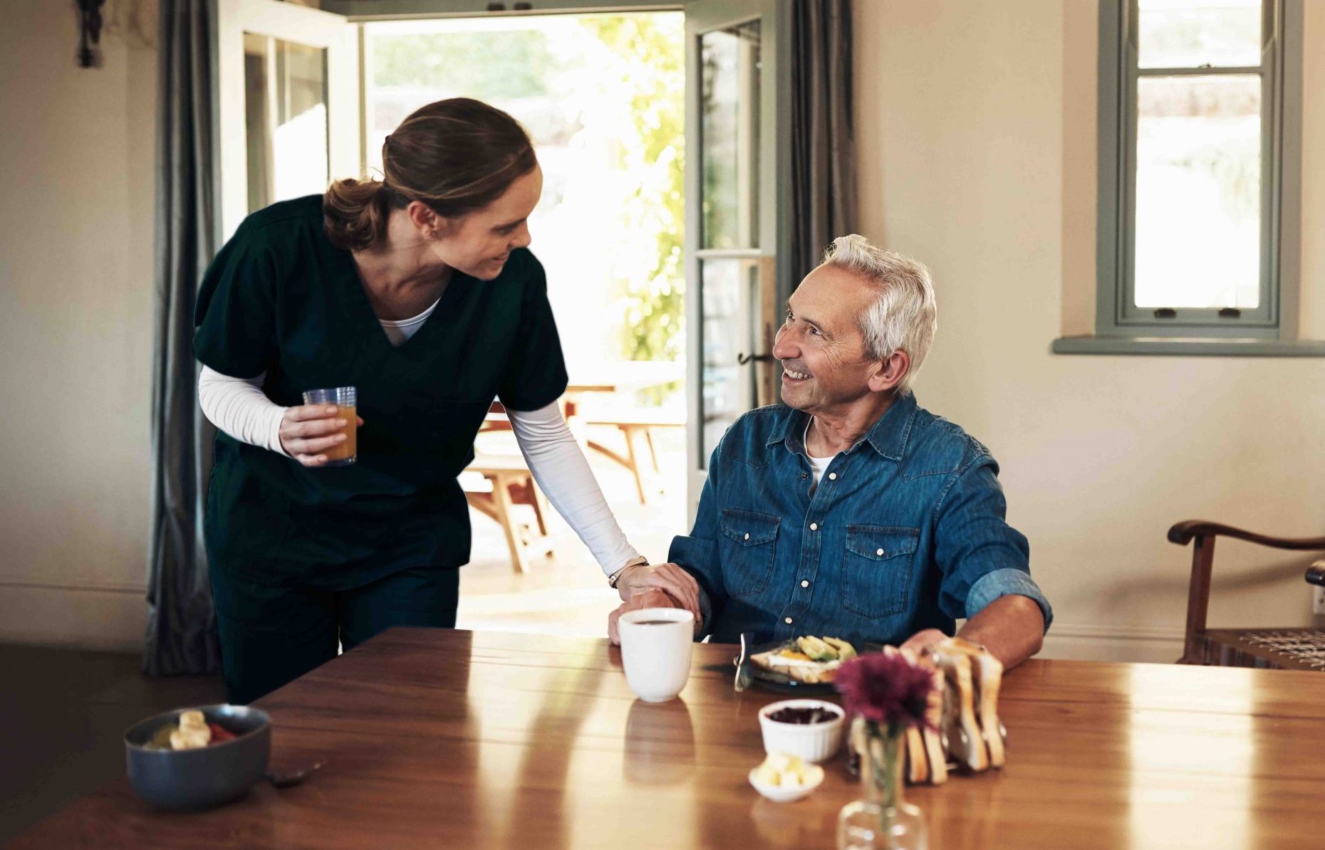 Caregiver giving a glass a juice to a senior client