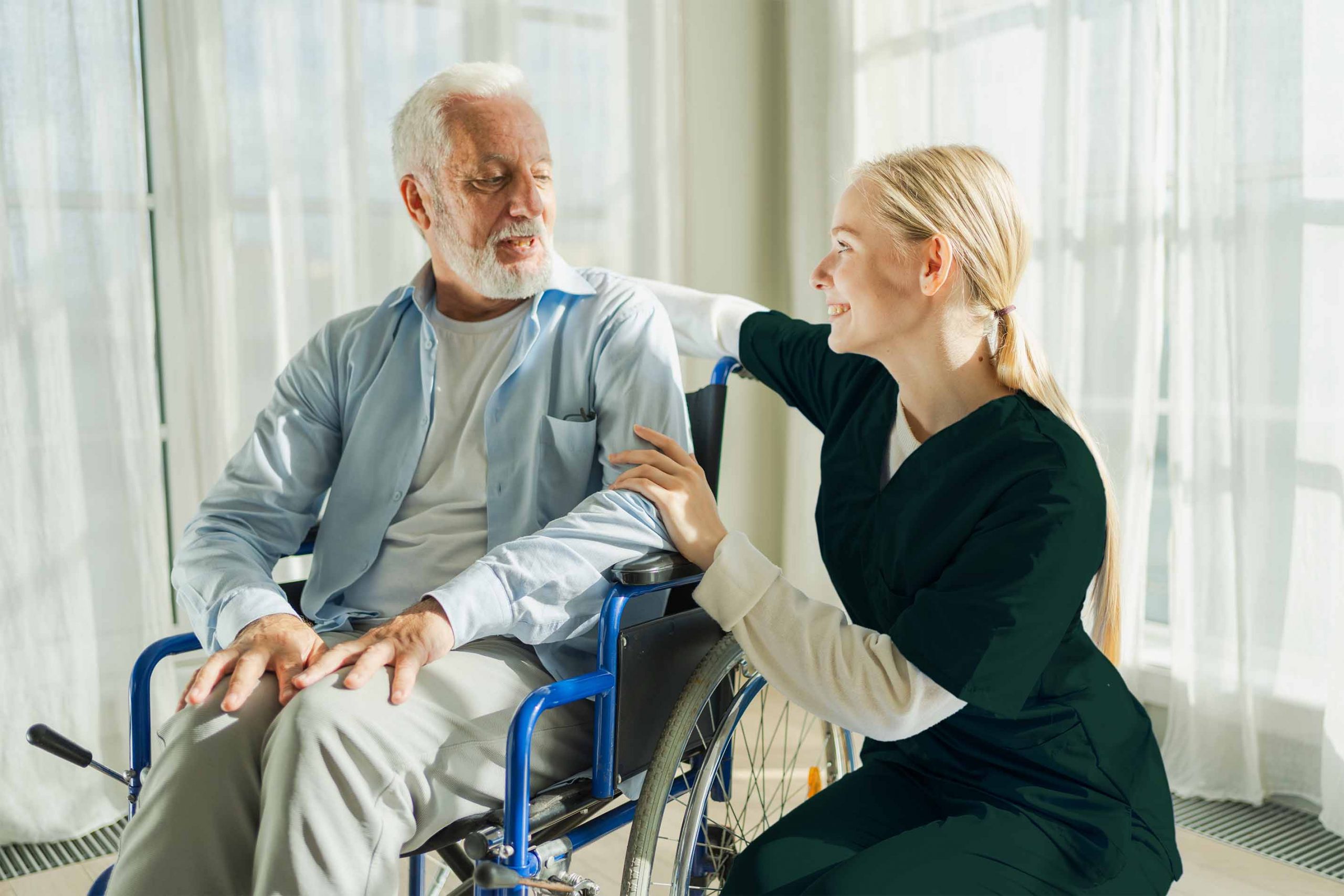 A woman assists an elderly man in a wheelchair, showcasing compassion and support at home.