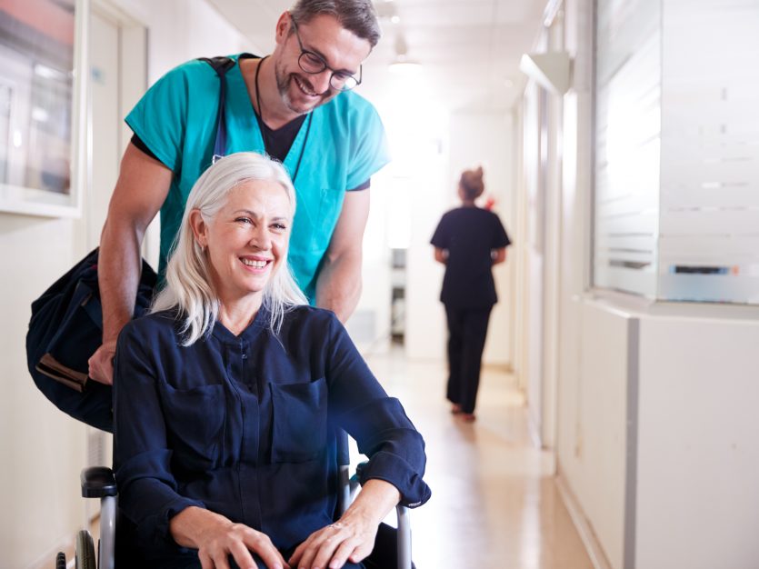 Make nurse assisting a senior sat in a wheelchair - Recovery at home