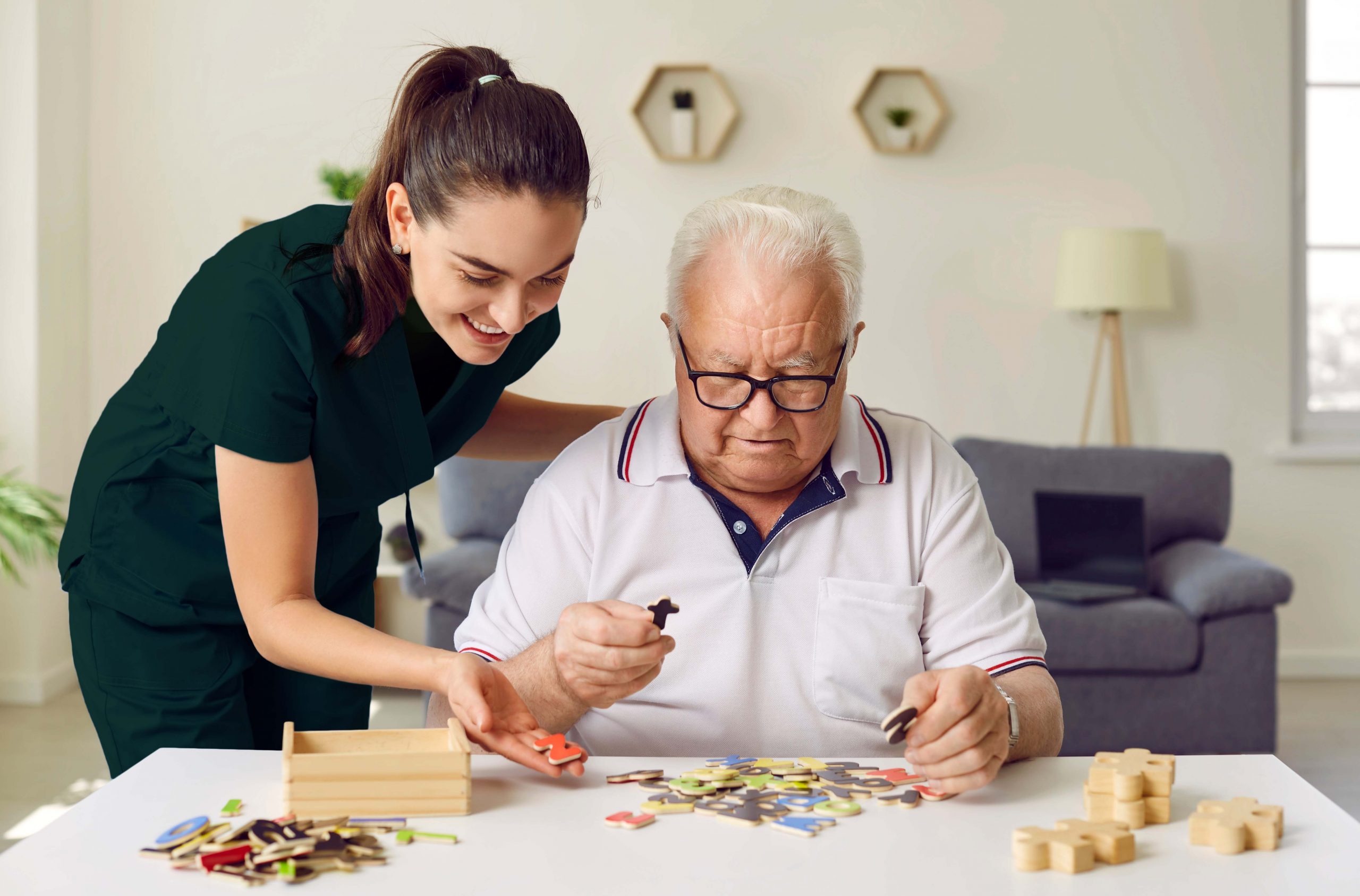 caregiver and seniors playing puzzle