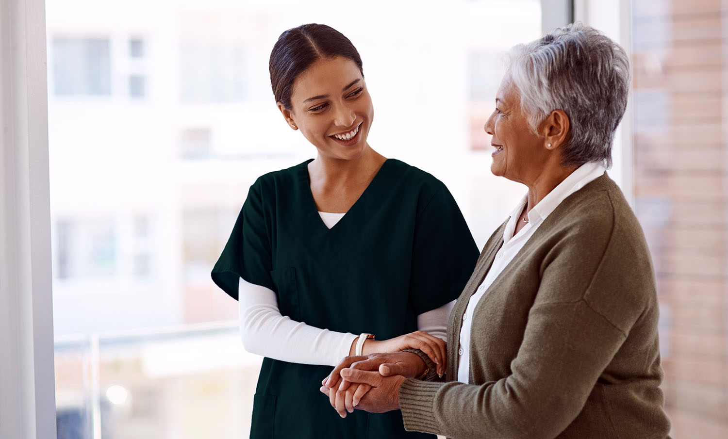 a woman holding a hand of an older woman