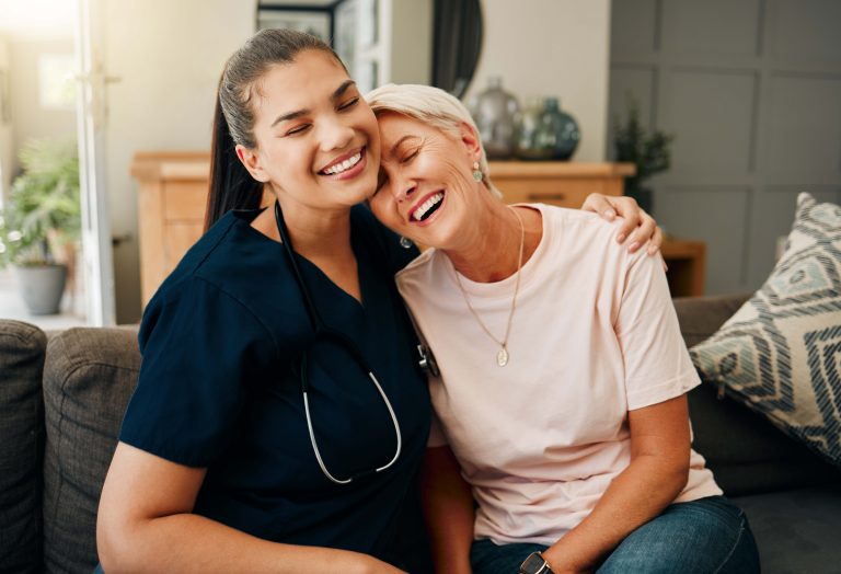 NHT A woman smiling with her eyes closed and a nurse hugging her
