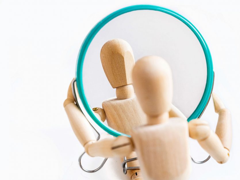 Understanding body dysmorphic disorder: It's not about vanity 5 a wooden figurine holding a round mirror