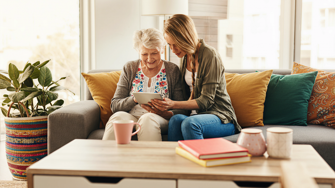 Protecting Seniors from Scams: What Canada’s New Anti-Scam Coalition Means for You and Your Loved Ones 1 A young woman helping a senior with ways to avoid scams - protecting seniors from scams