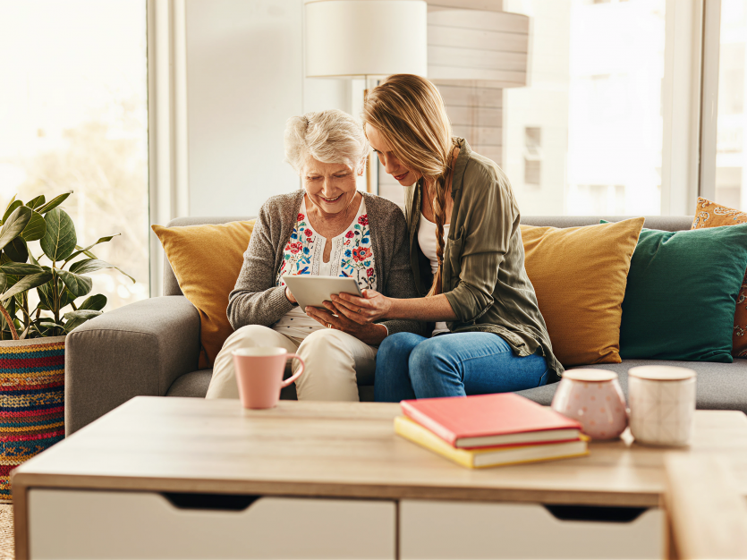 Protecting Seniors from Scams: What Canada’s New Anti-Scam Coalition Means for You and Your Loved Ones 2 A young woman helping a senior with ways to avoid scams - protecting seniors from scams