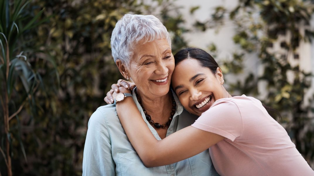 Senior woman and daughter in their yard