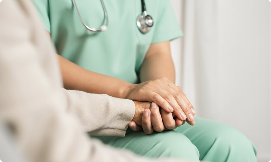 Healthcare professional holding patient's hands