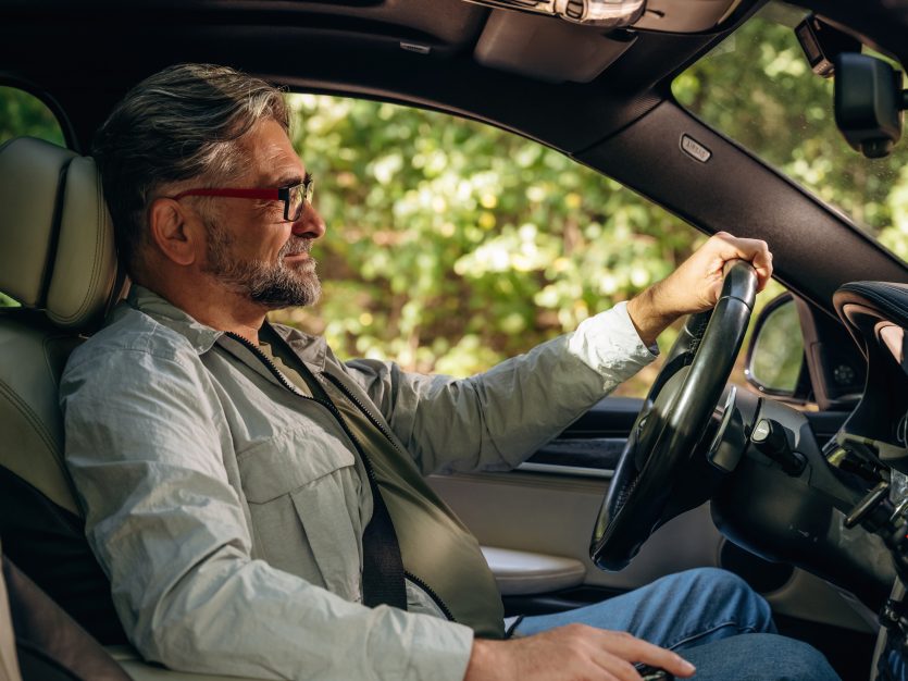 Side view of senior man that is driving a car.