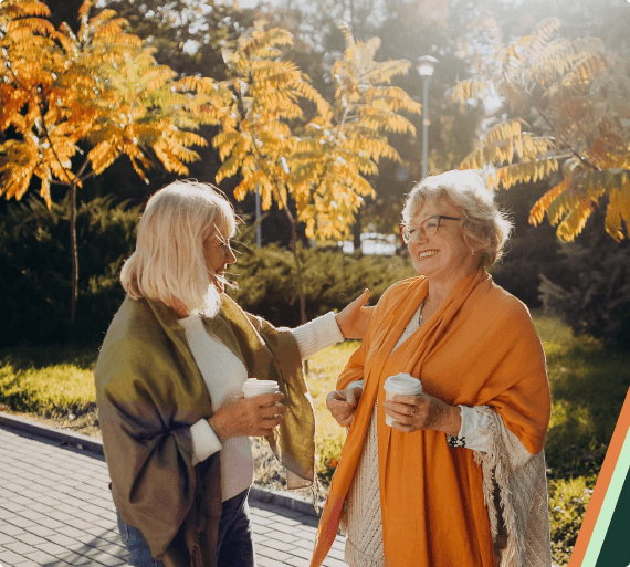 Two older adult standing outside in fall