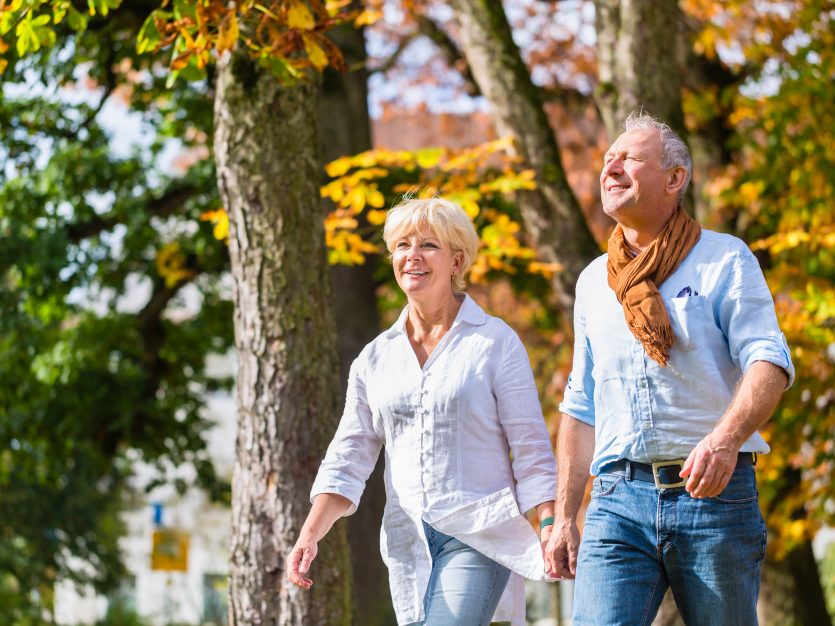 Happy elderly couple walking during fall season