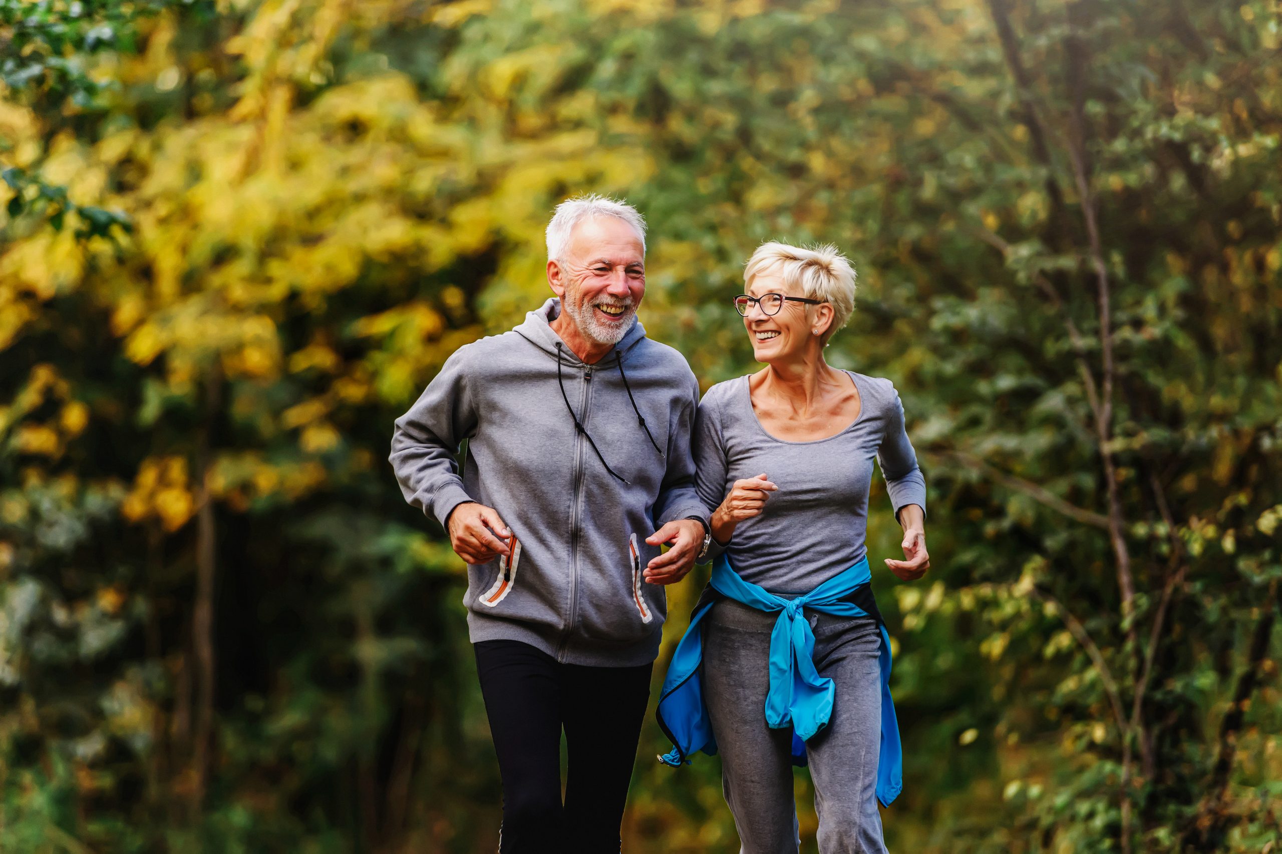 Smiling senior couple jogging in the park