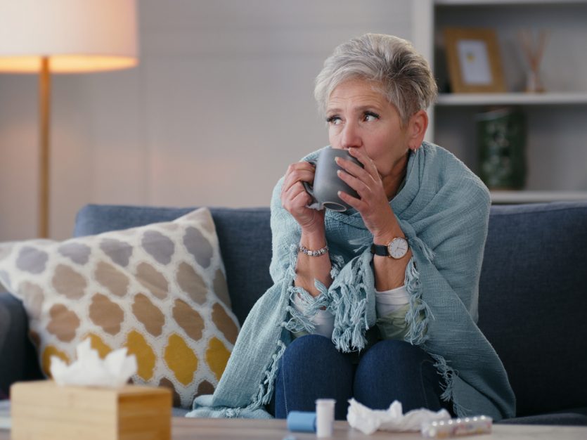 Woman sipping tea, cozy living room.