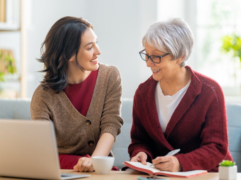 Two women smiling and conversing together.