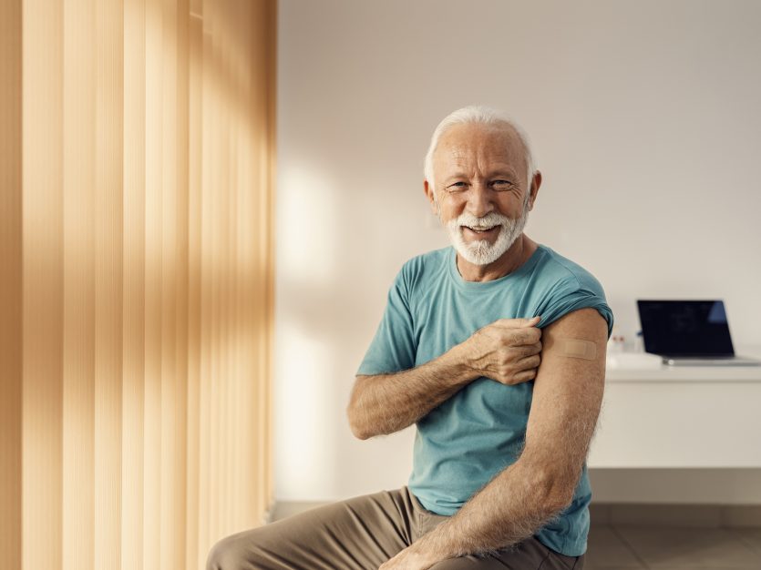 Smiling elderly man with vaccination bandage